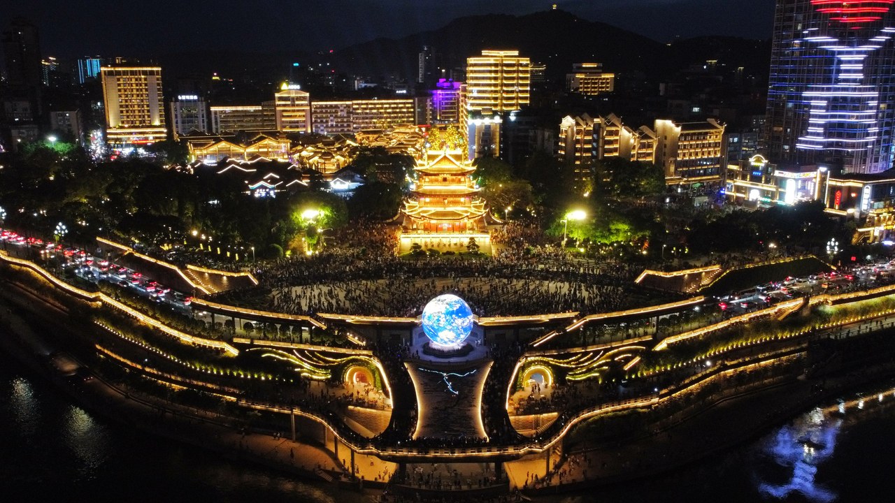 Hejiangmen waterfront square and illuminated buildings beside the rivers in Yibin at night.