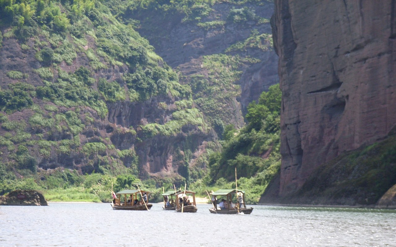 Bamboo rafts on the Luxi River between red-brown Danxia cliffs at Longhushan.