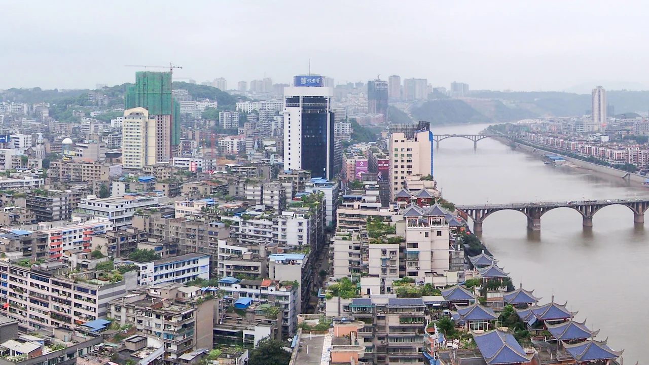 An elevated historical view of Luzhou city beside a broad river, with bridges and riverside pavilion roofs.
