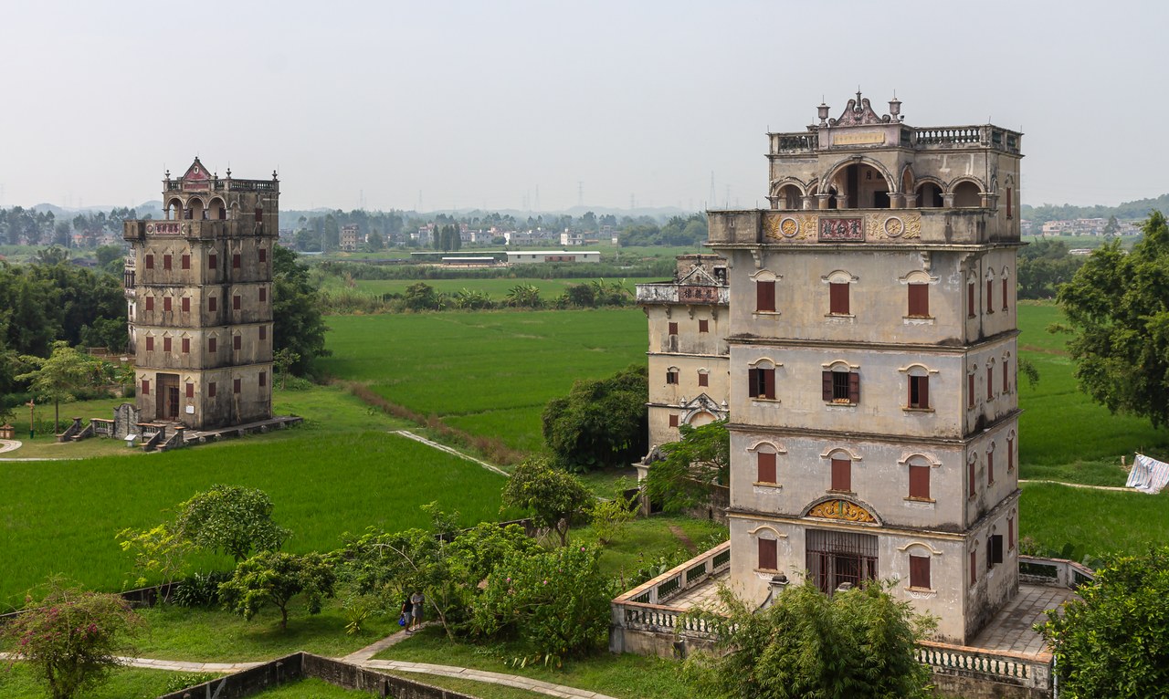 Yunhuan Lou and Yangxian Villa rise beside green fields in Zili Village, Kaiping.