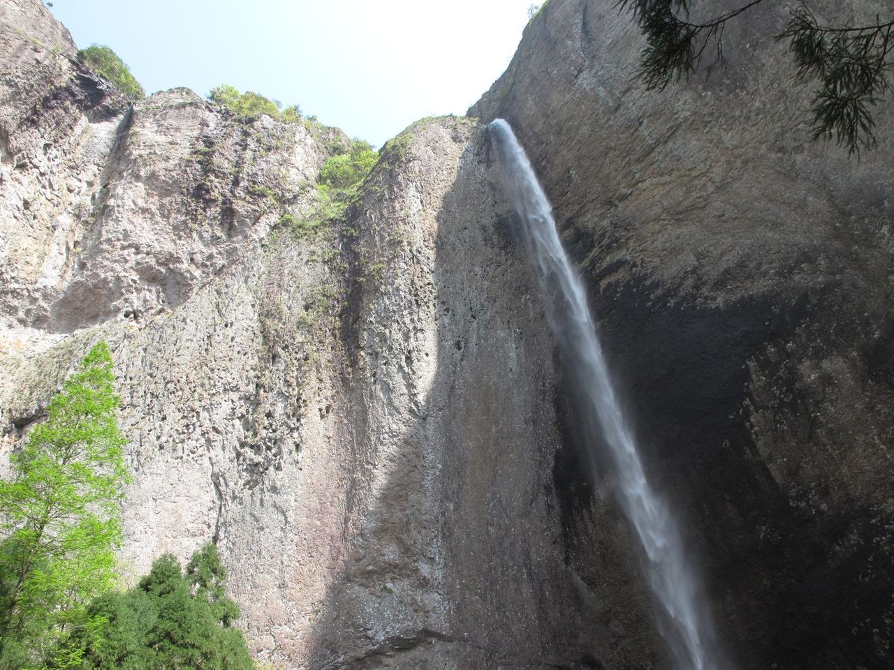 Dalongqiu Waterfall descends over a high curved rock wall at Yandangshan.