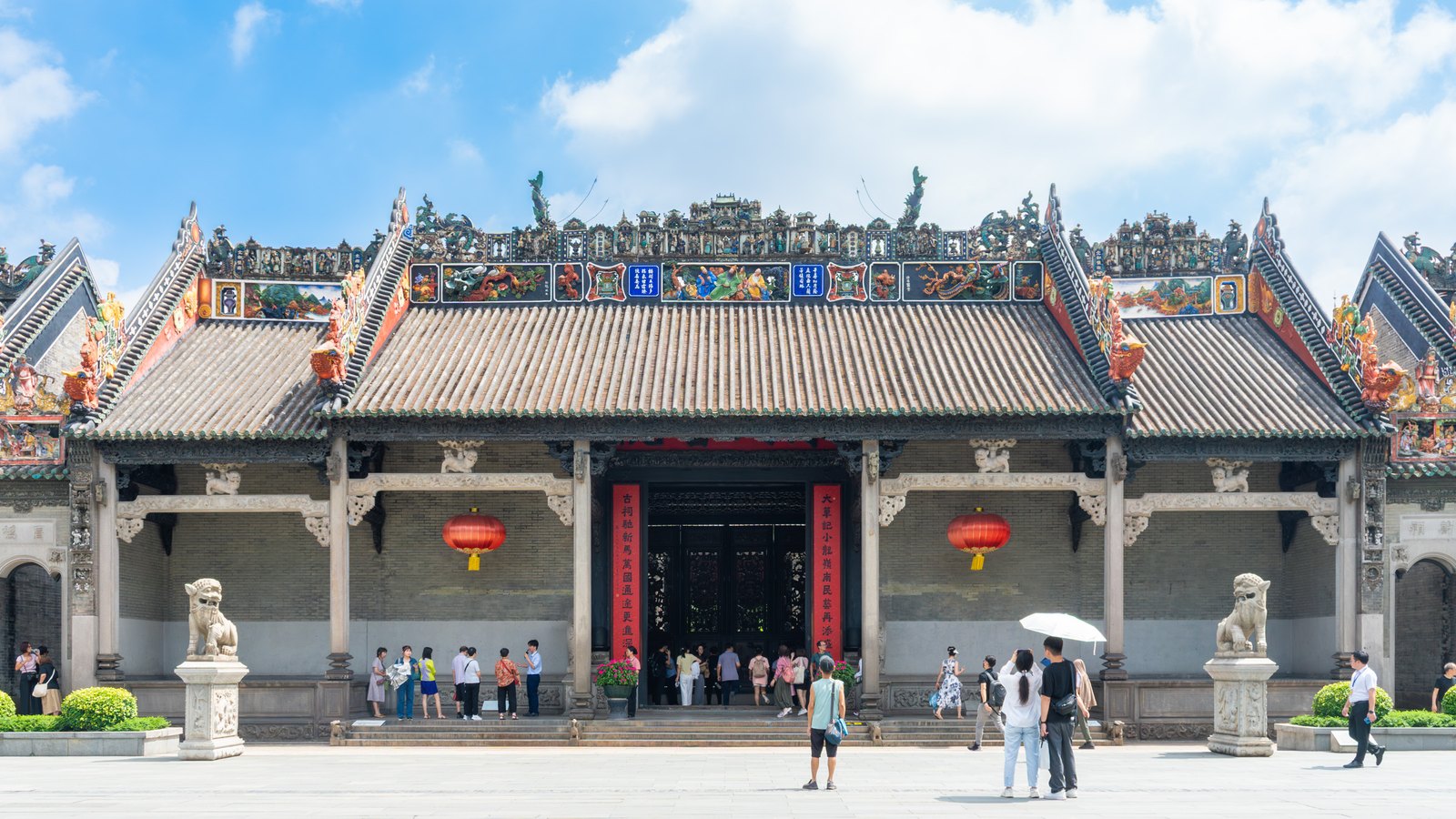 Ornate roof ridges, grey brick walls and red lanterns at Chen Clan Ancestral Hall in Guangzhou.
