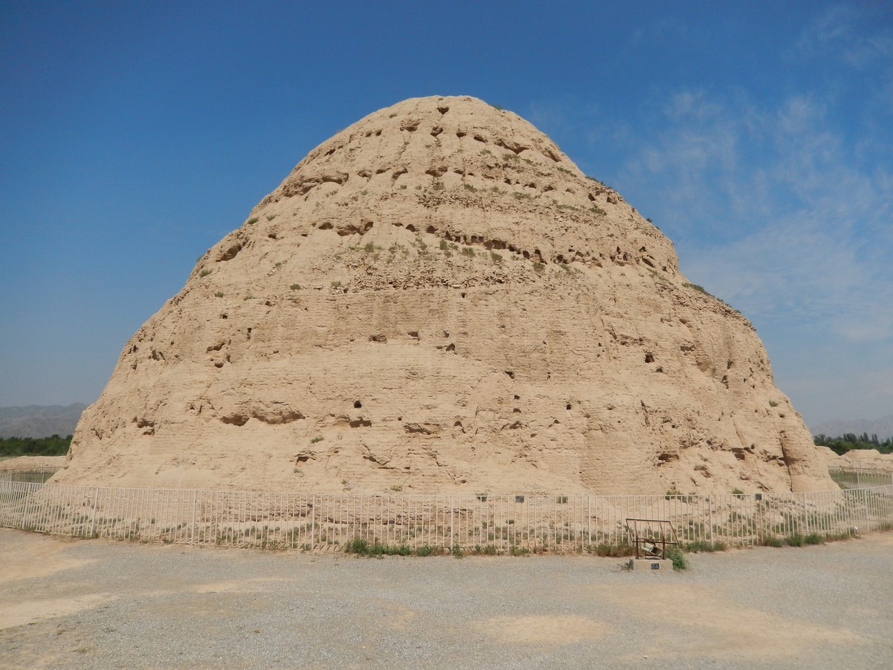 The surviving rammed-earth mound of Western Xia Tomb 3 beneath a blue sky.
