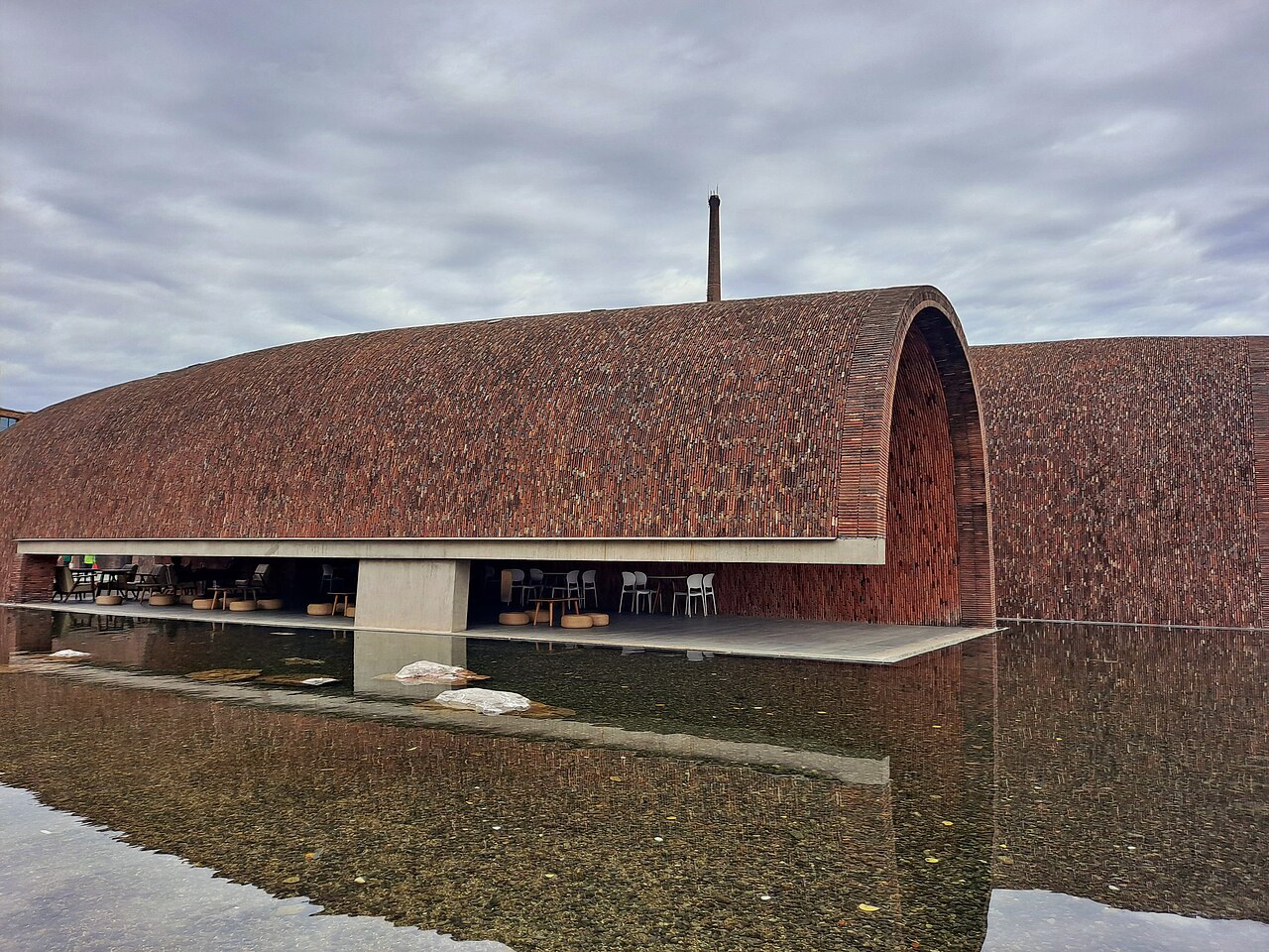 Brick vaults of Jingdezhen Imperial Kiln Museum reflected in a shallow pool