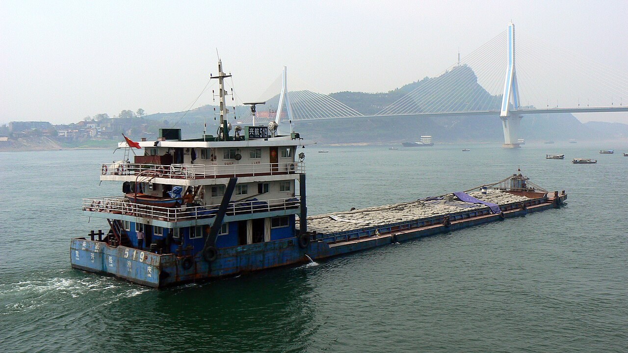 A cargo vessel on the Yangtze River at Yichang, with a cable-stayed bridge in the background.
