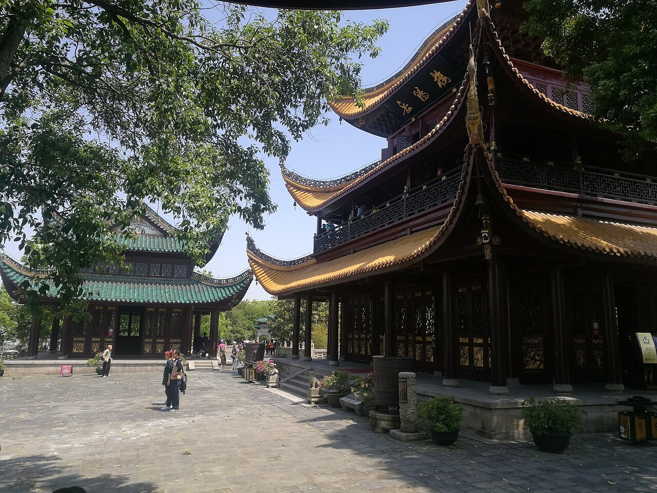 Yueyang Tower’s golden curved roofs and timber balconies seen from the side of its courtyard.