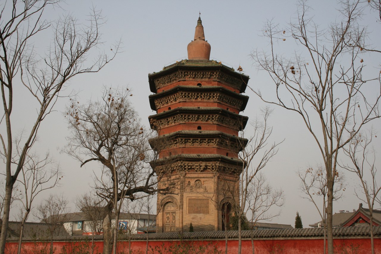 Wenfeng Pagoda rising above the temple wall and bare trees in Anyang