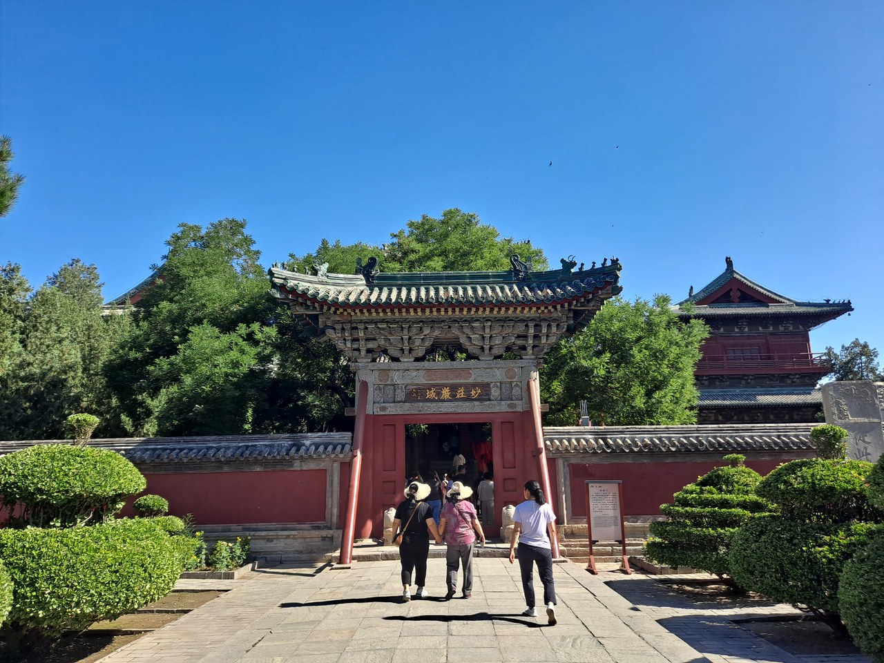 Visitors walking through a decorated gate at Longxing Temple in Zhengding
