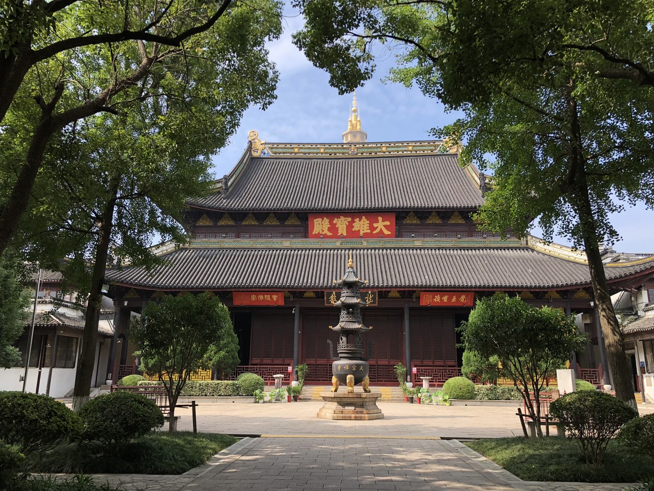 The main hall at Tianning Temple framed by green trees
