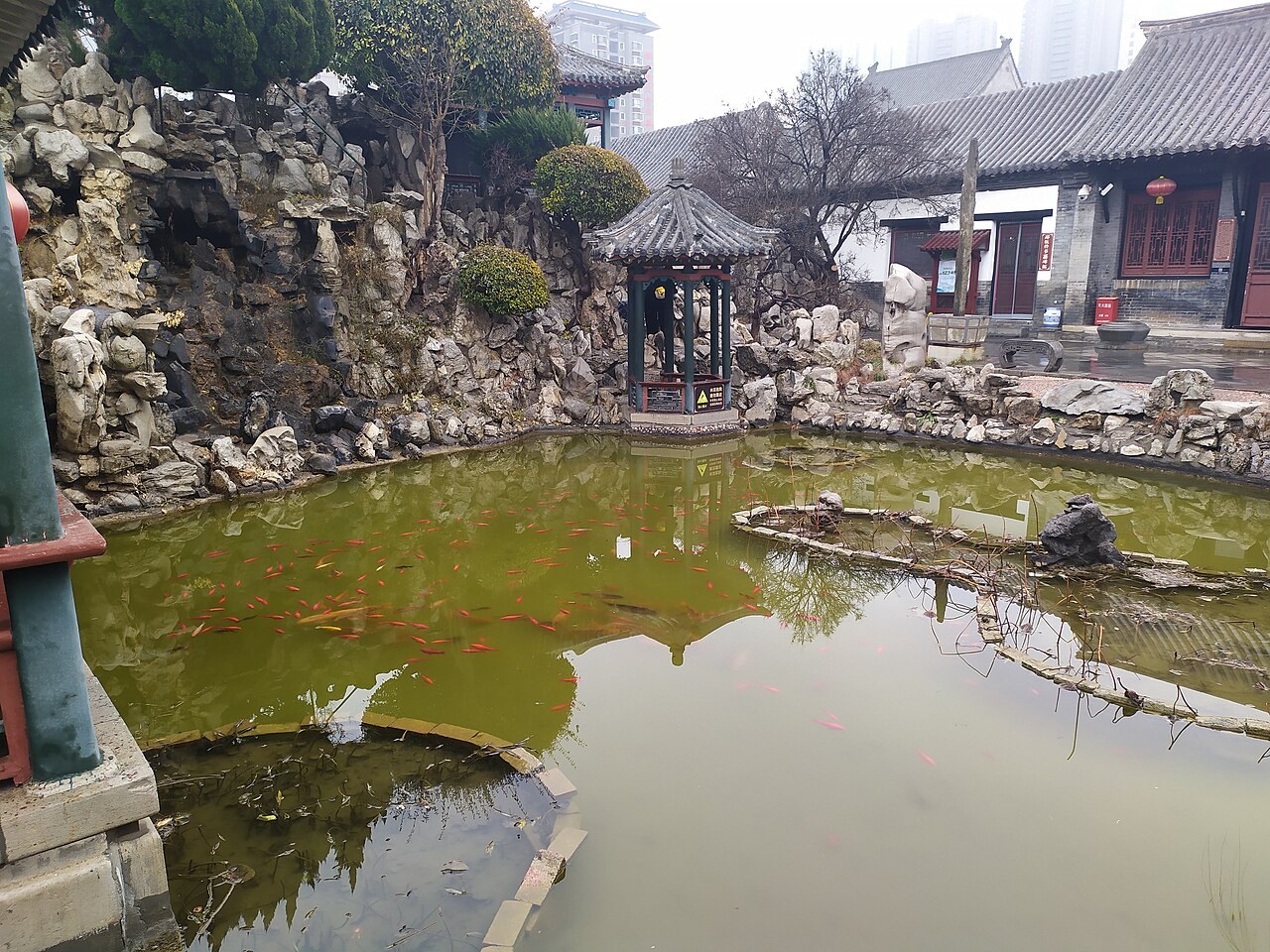 Rockwork, a pond and a small pavilion in Shihu Garden, Weifang