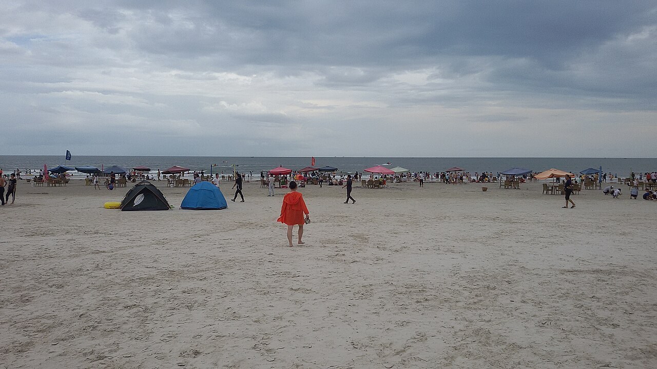 Visitors on the broad sand of Beihai Silver Beach, with the Gulf of Tonkin beyond.