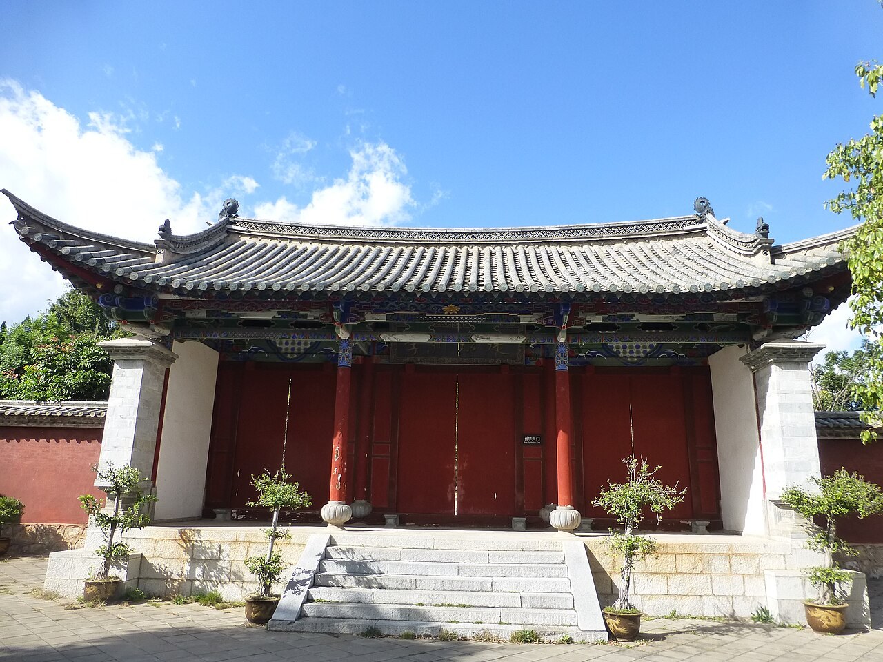 A red-walled building and stone steps within Jianshui Confucian Temple.