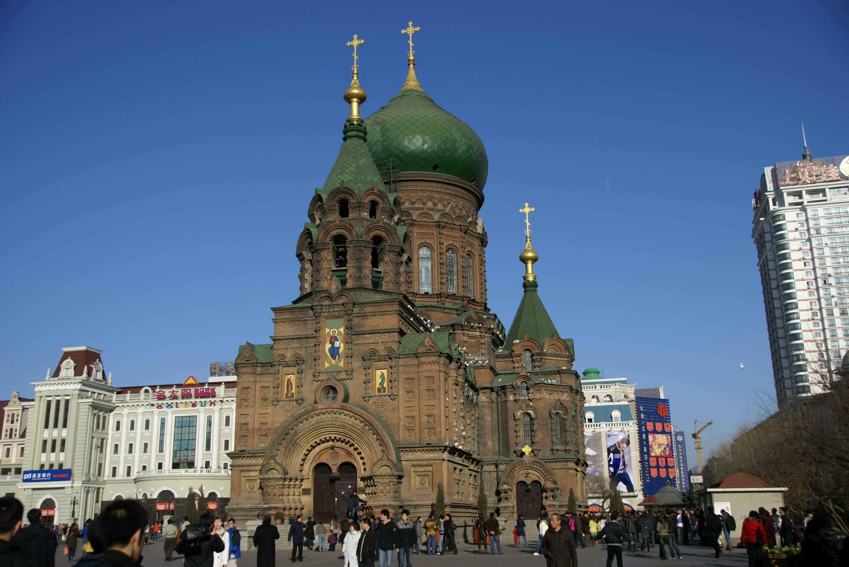 Saint Sophia’s green dome and brick façade seen across its public square.