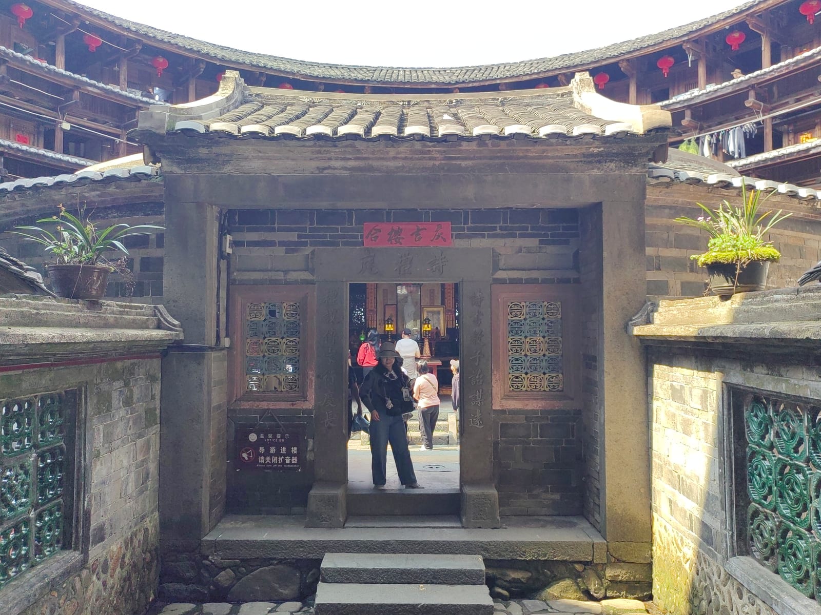 Huaiyuan Lou’s carved inner hall stands inside the circular timber galleries.