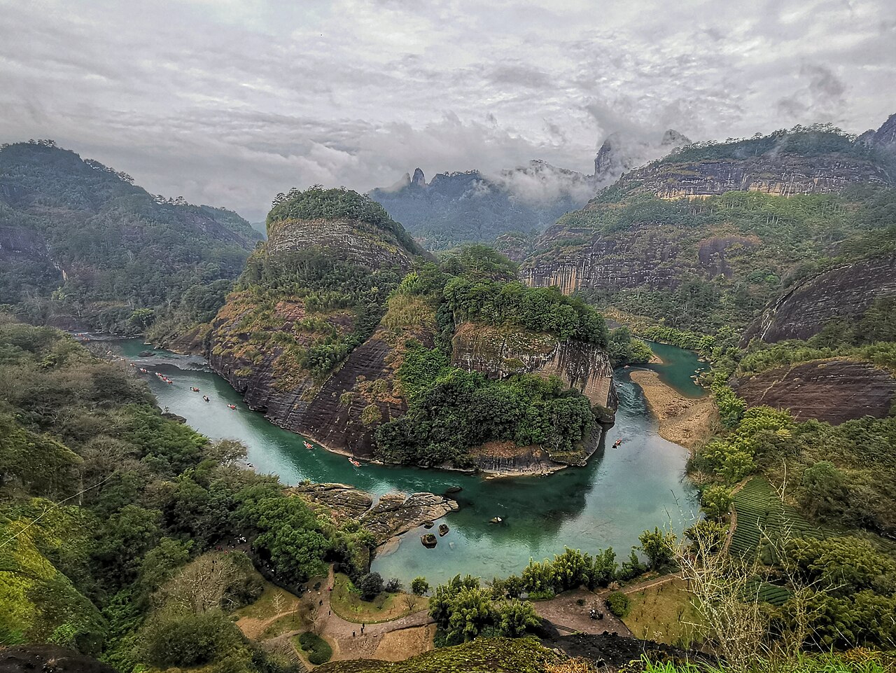 Green Nine-Bend River curling around steep layered cliffs below the Tianyou walking trail.