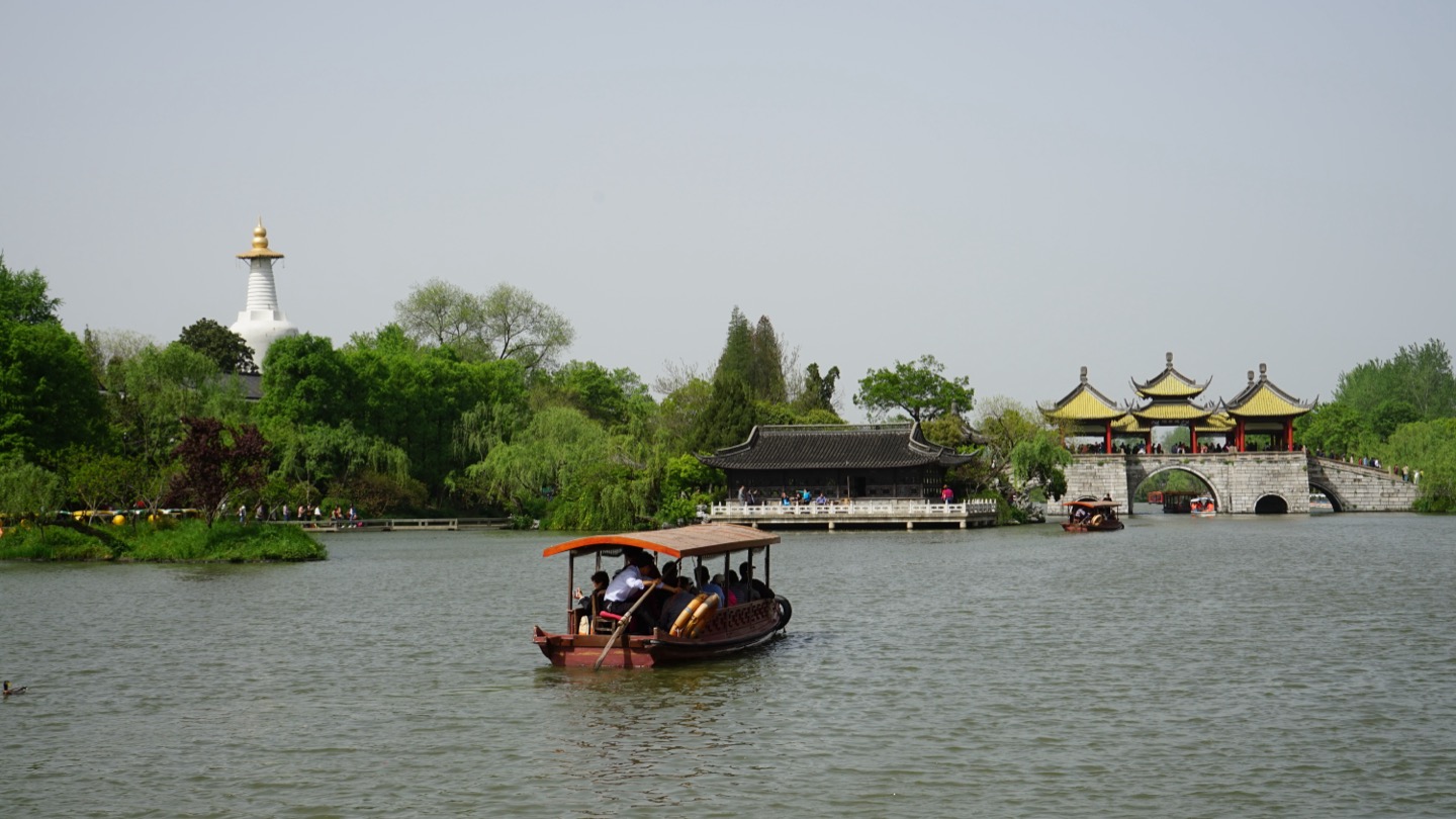 Five-Pavilion Bridge, the White Pagoda and a small passenger boat on Slender West Lake.